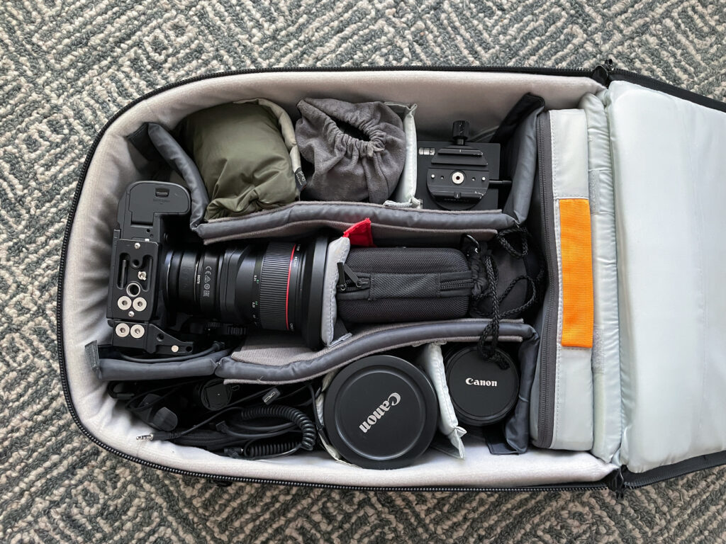 Photo of a photographer's camera bag with camera and lenses.
